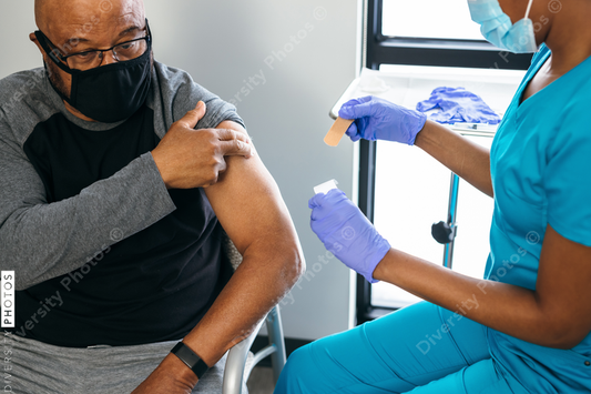 Black senior man gets vaccine, from nurse at doctors office
