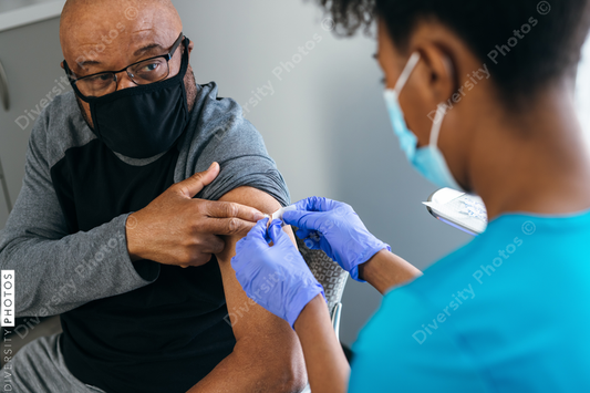 Black senior man gets vaccine, from nurse at doctors office