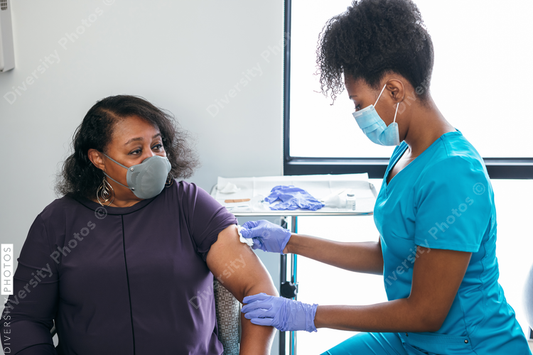 Black senior woman gets vaccine, from nurse at doctors office