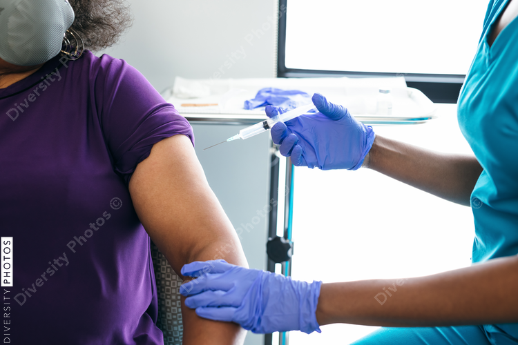 Black senior woman gets vaccine, from nurse at doctors office