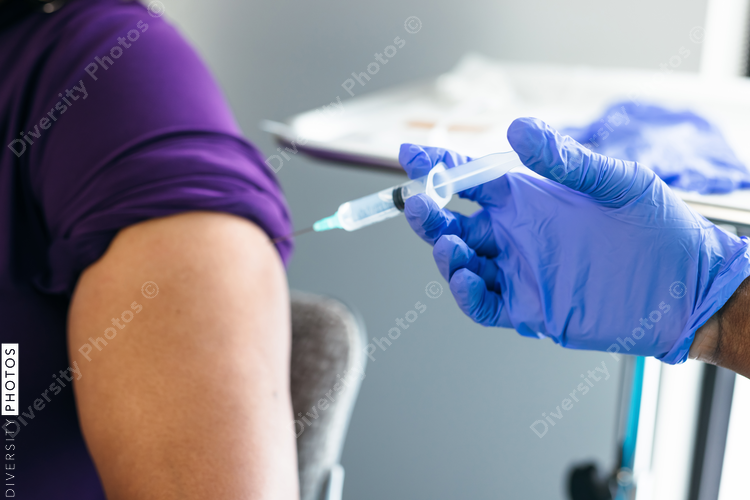 Black senior woman gets vaccine, from nurse at doctors office