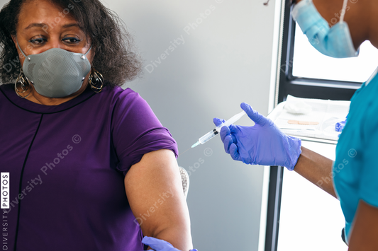Black senior woman gets vaccine, from nurse at doctors office