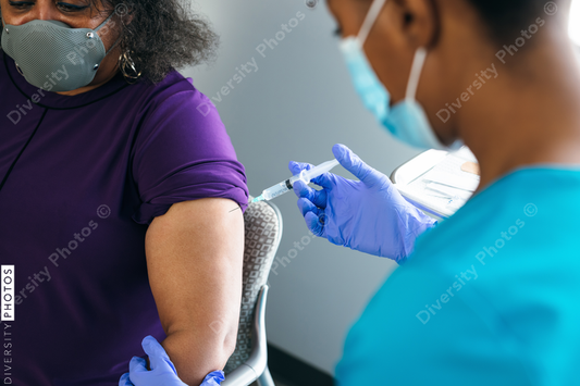 Black senior woman gets vaccine, from nurse at doctors office