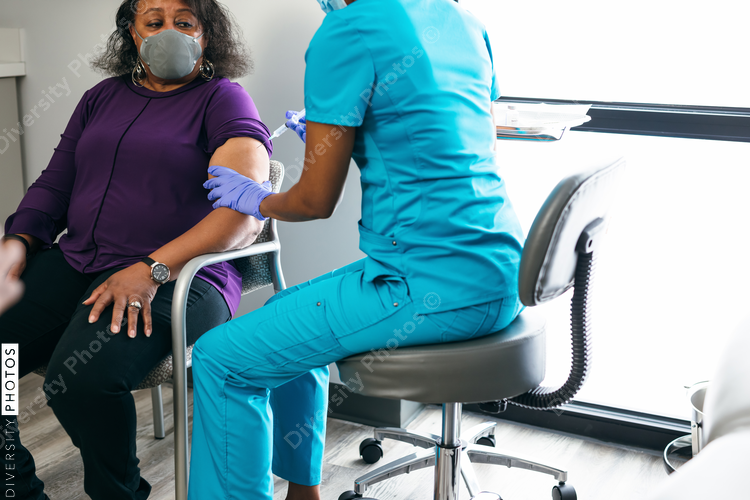 Black senior woman gets vaccine, from nurse at doctors office