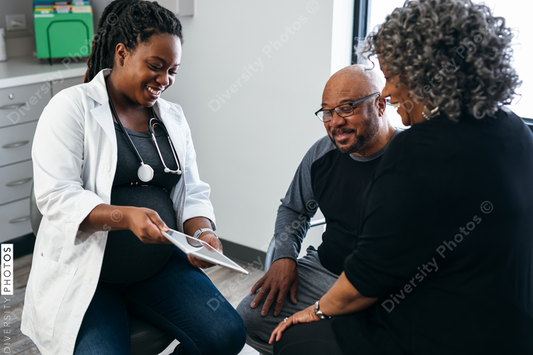 Black pregnant doctor consulting with senior patients 