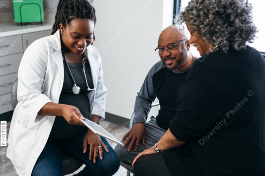 Black pregnant doctor consulting with senior patients 