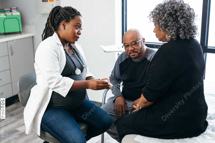 African American female doctor consults with senior medical patients about prescription drugs