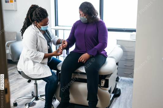 Black doctor consulting with senior patient 