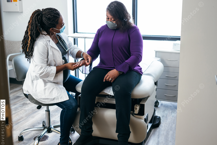 Black doctor consulting with senior patient 