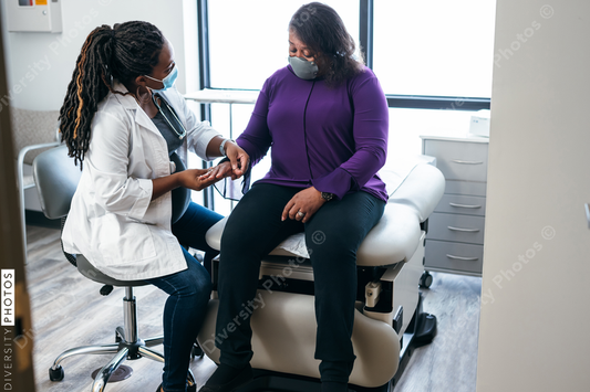 Black doctor consulting with senior patient 