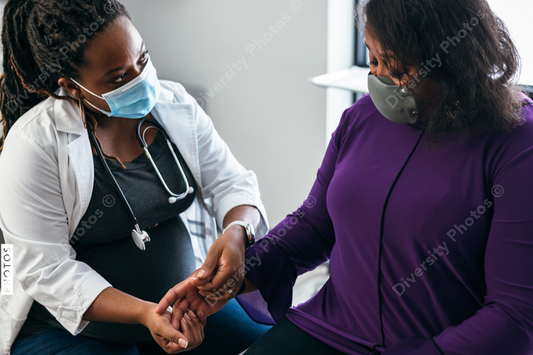 Black doctor consulting with senior patient 