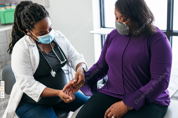 Black doctor consulting with senior patient 