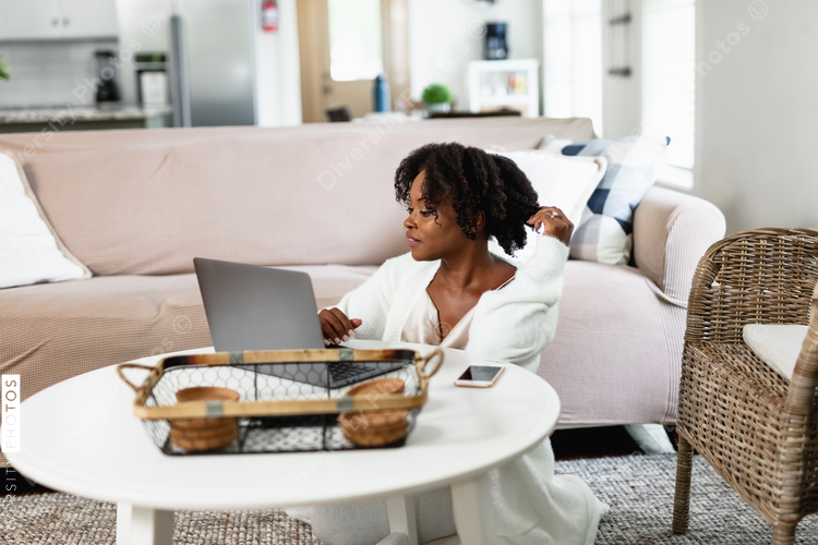 Woman working from home, comfortably on floor in family room, video chat