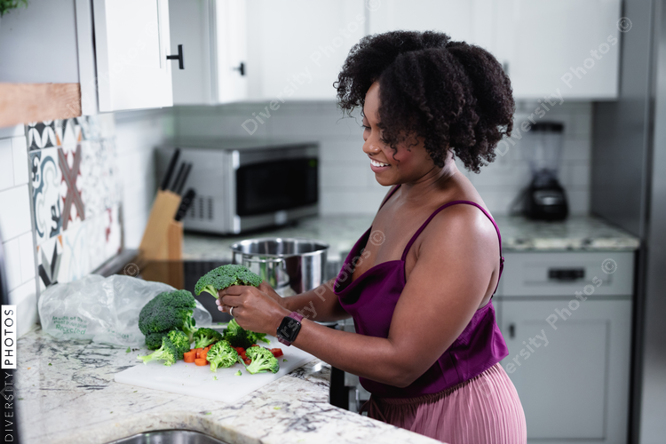Black woman cooking at home, healthy vegetables 