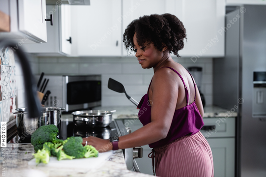 Black woman cooking at home, healthy vegetables 