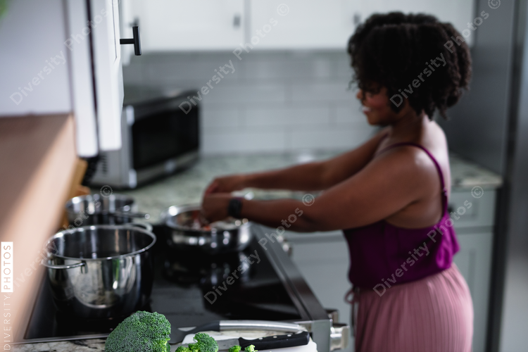 Black woman cooking at home, healthy vegetables 
