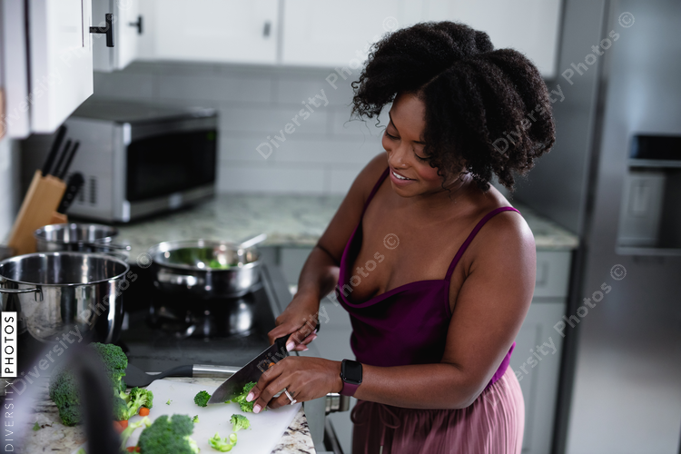 Black woman cooking at home, healthy vegetables 