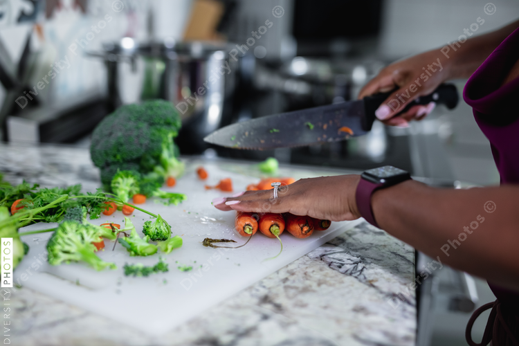 Woman dicing vegetables in kitchen, healthy