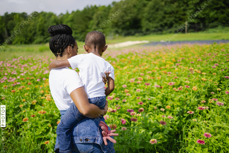 Rear view of mother and son standing in field