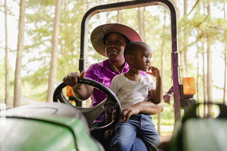 Grandmother with grandson sitting on tractor in rural environment
