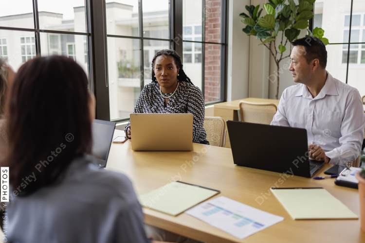 Mid adult Black business leader, having discussions with team, female