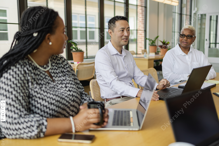 Mature Chinese business leader, having discussions with team, male