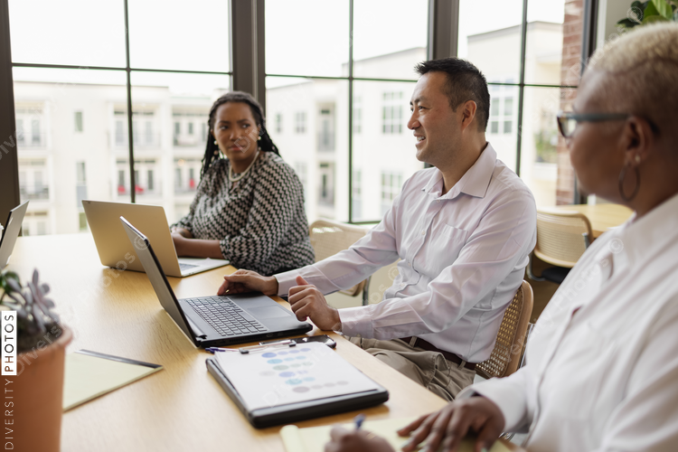 Mature Chinese business leader, having discussions with team, male