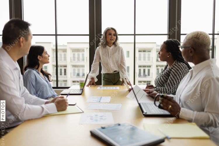 Mature Asian woman leading business team meeting
