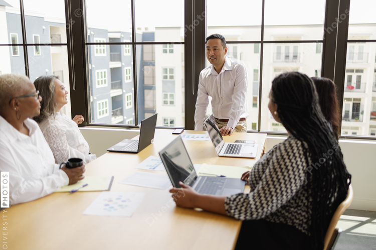 Mature Asian man leading business team meeting