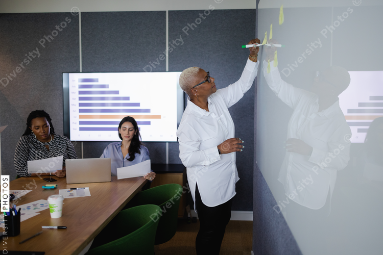 Diverse business team brainstorming and collaborates in conference room, senior Black woman leadership