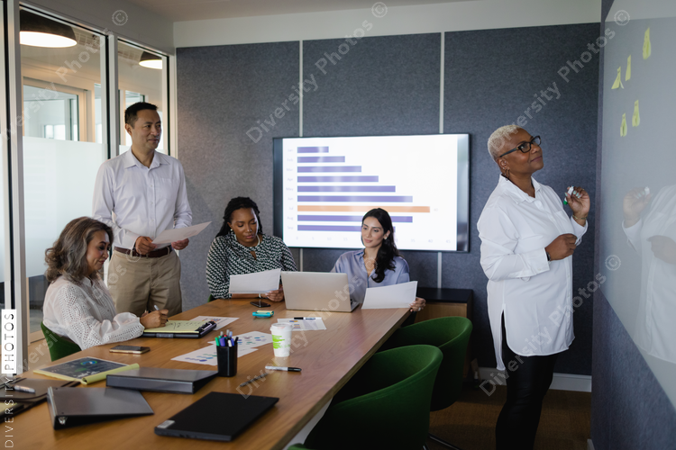 Diverse business team brainstorming and collaborates in conference room, senior Black woman leadership