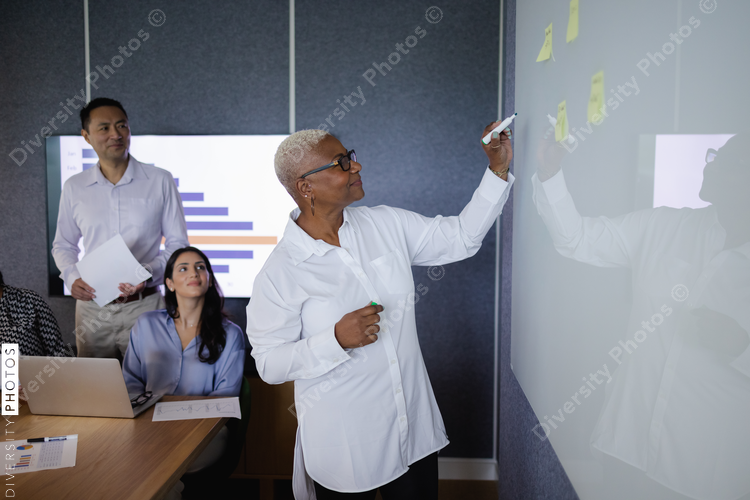 Diverse business team brainstorming and collaborates in conference room, senior Black woman leadership