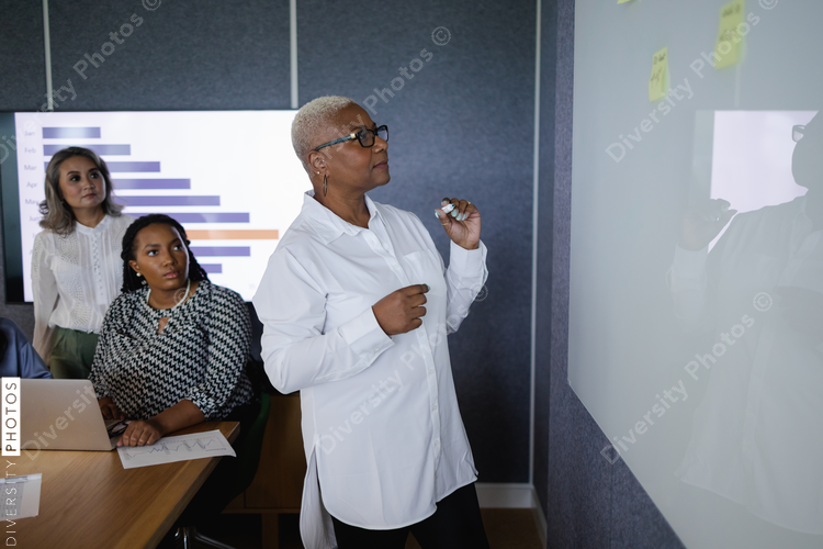 Diverse business team brainstorming and collaborates in conference room, senior Black woman leadership