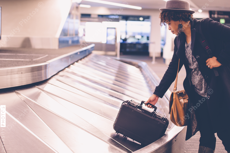 Businesswoman collecting luggage from baggage claim at airport