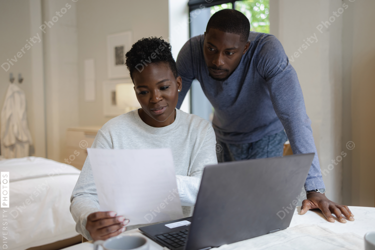 Couple reading document and using laptop