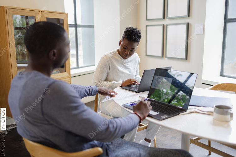 Man and woman working on laptops at home
