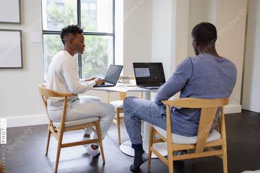 Black Man and woman working on laptops at home