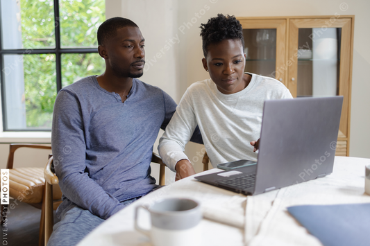 Black Couple using laptop at home, focused paying bills