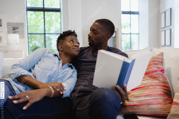 Couple reading book on sofa, Black
