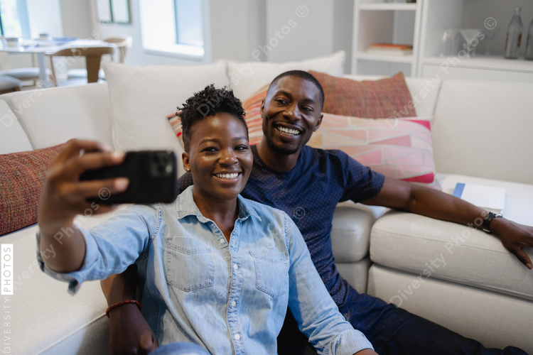 Couple sitting in living room and taking selfie