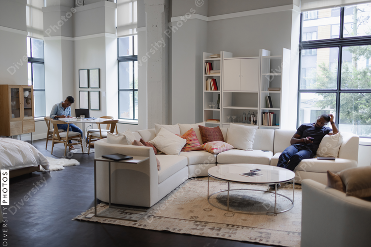 Man and woman relaxing in modern living room, African American