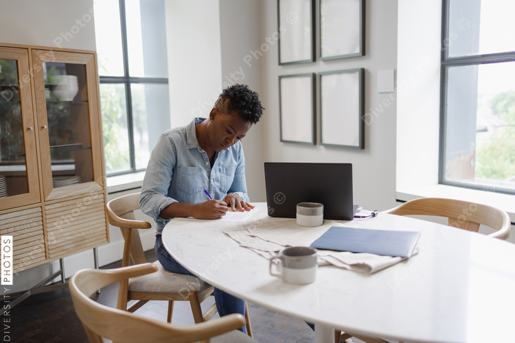 Woman sitting at table and filling documents