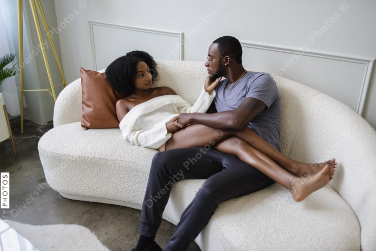 Couple relaxing on sofa and holding hands