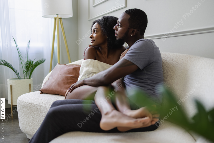 African American Couple sitting on sofa and embracing