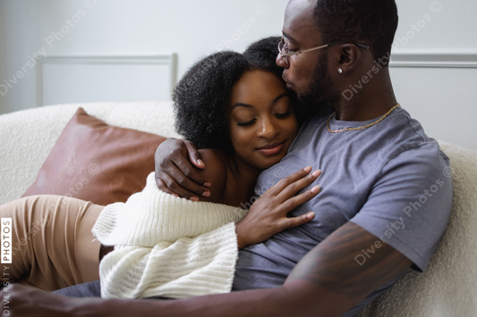 Black Couple hugging on sofa, comfortable 