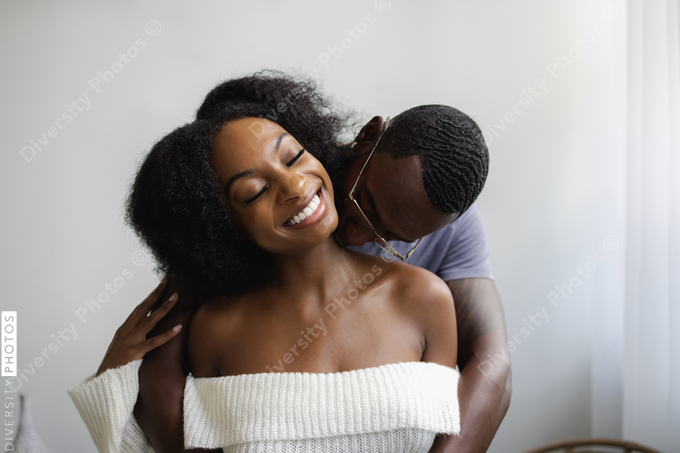 African American Boyfriend kissing smiling girlfriend