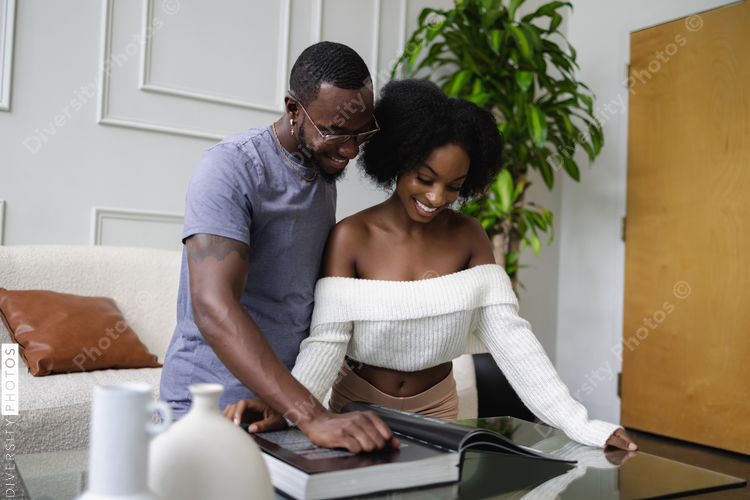 Smiling Black couple looking through book