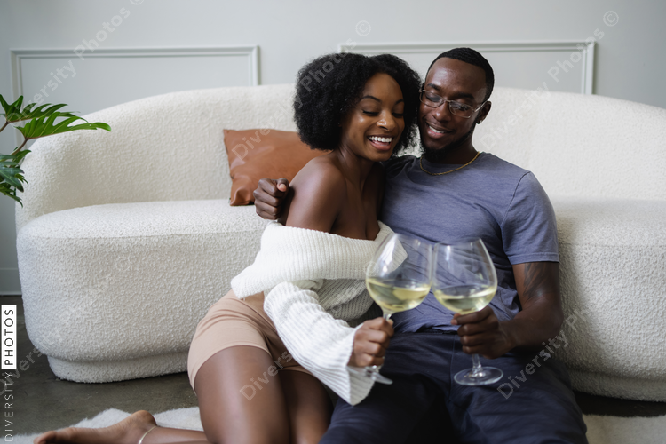 Smiling couple cuddling and toast celebrating buying new home together