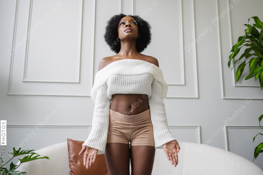 Young woman doing tadasana yoga pose in living room
