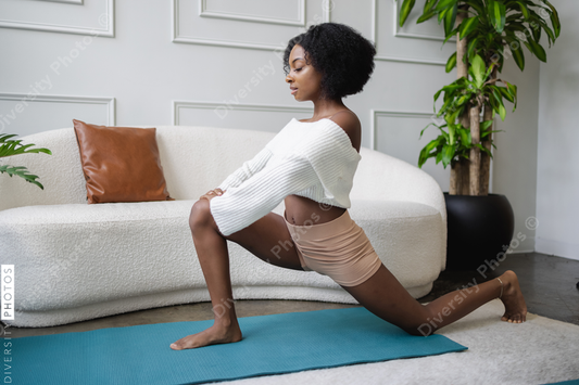 Young woman doing lunge yoga pose in living room
